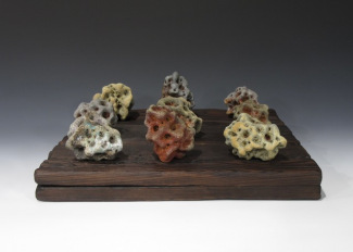 "Logical Leavings," Wood/Soda Fired Stoneware, Displayed on Charred Wood, by Tina Opp